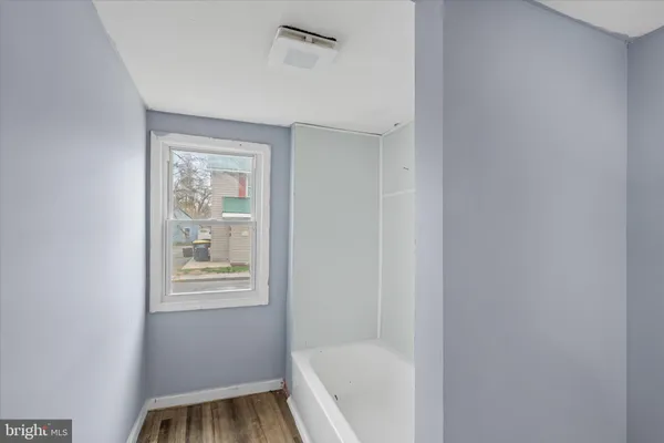 a bathroom with a bathtub window and vanity
