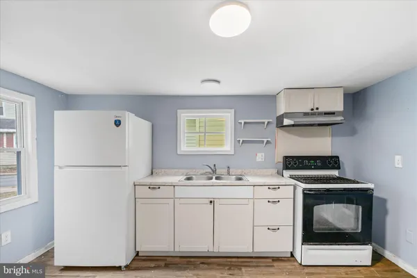 a kitchen with a stove cabinets and a refrigerator