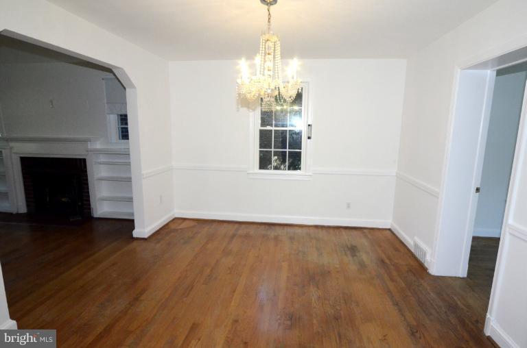 9610 Wire Avenue Silver Spring, MD 20901 - Photo 13 of 23 an empty room with wooden floor fireplace and windows
