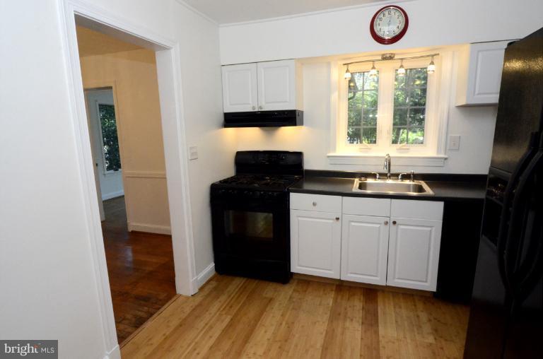 9610 Wire Avenue Silver Spring, MD 20901 - Photo 17 of 23 a kitchen with a sink a window appliances and cabinets
