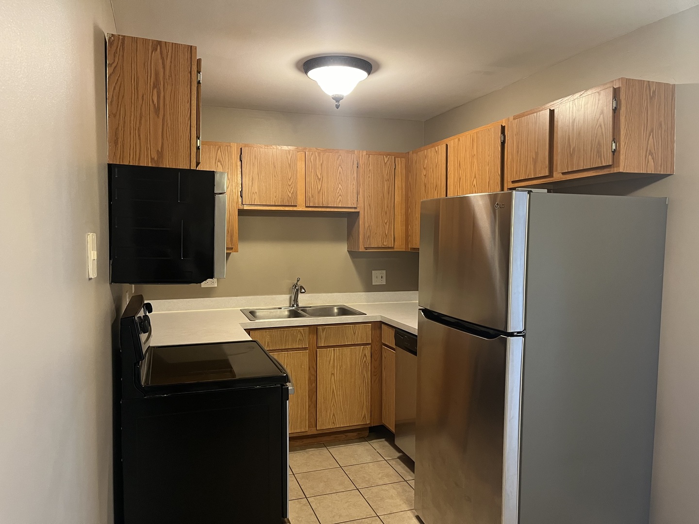 2300 Light Road, Unit 201 Oswego, IL 60543 - Photo 7 of 10 a kitchen with a sink a refrigerator and cabinets
