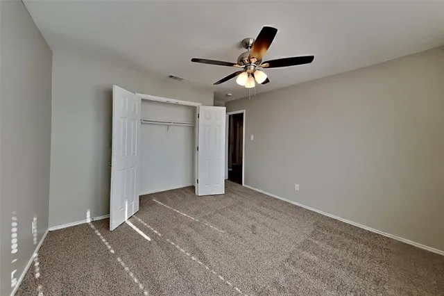 a view of room with ceiling fan and window