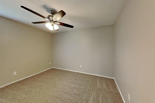 an empty room with a chandelier fan and a fan