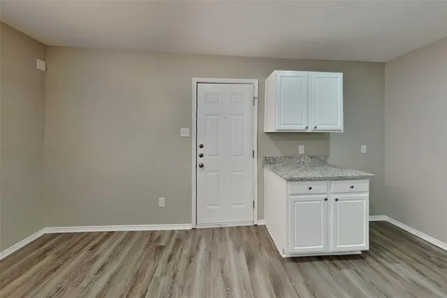 a view of kitchen with granite countertop cabinets and wooden floor