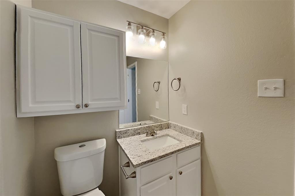 5804 Mirror Ridge Drive Fort Worth, TX 76179 - Photo 10 of 19 a bathroom with a granite countertop sink a toilet and mirror