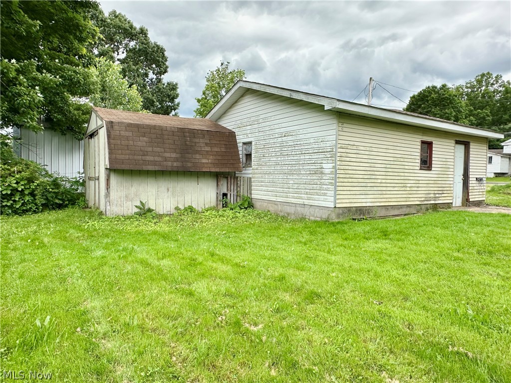 6841 Warren - Sharon Road Brookfield, OH 44403 - Photo 31 of 32 View of side of property featuring a lawn and a storage shed