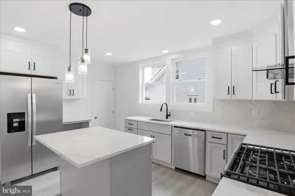 a kitchen with white cabinets appliances and sink