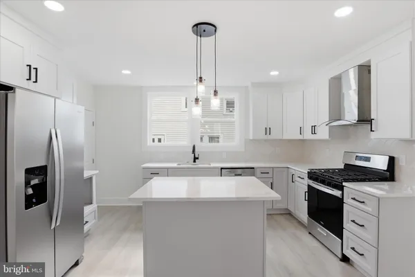 a kitchen that has a refrigerator a sink and cabinets