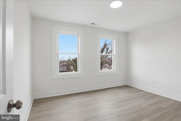 an empty room with windows and closet
