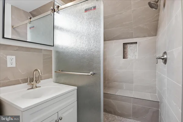 a bathroom with a sink mirror and shower