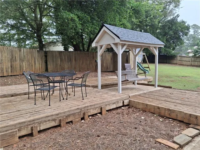 a view of a house with backyard and sitting area