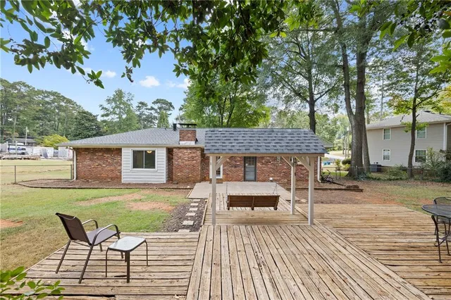 a view of a roof deck with table and chairs with wooden floor and fence