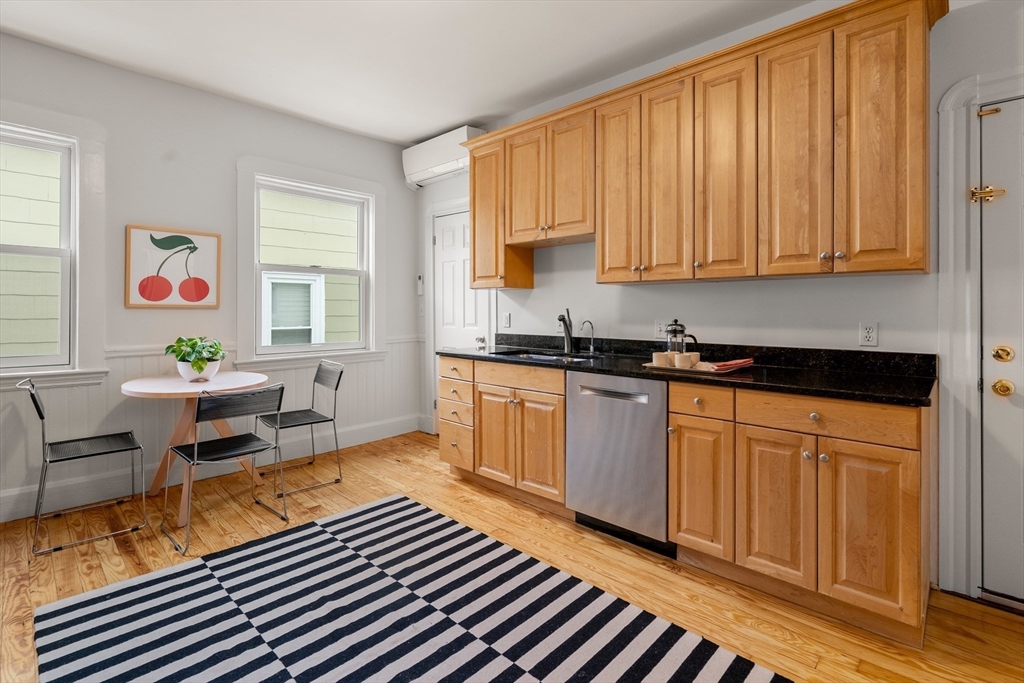 206 Pearl Street, Unit 3 Somerville, MA 02145 - Photo 11 of 18 a kitchen with stainless steel appliances granite countertop a refrigerator a sink and wooden cabinets