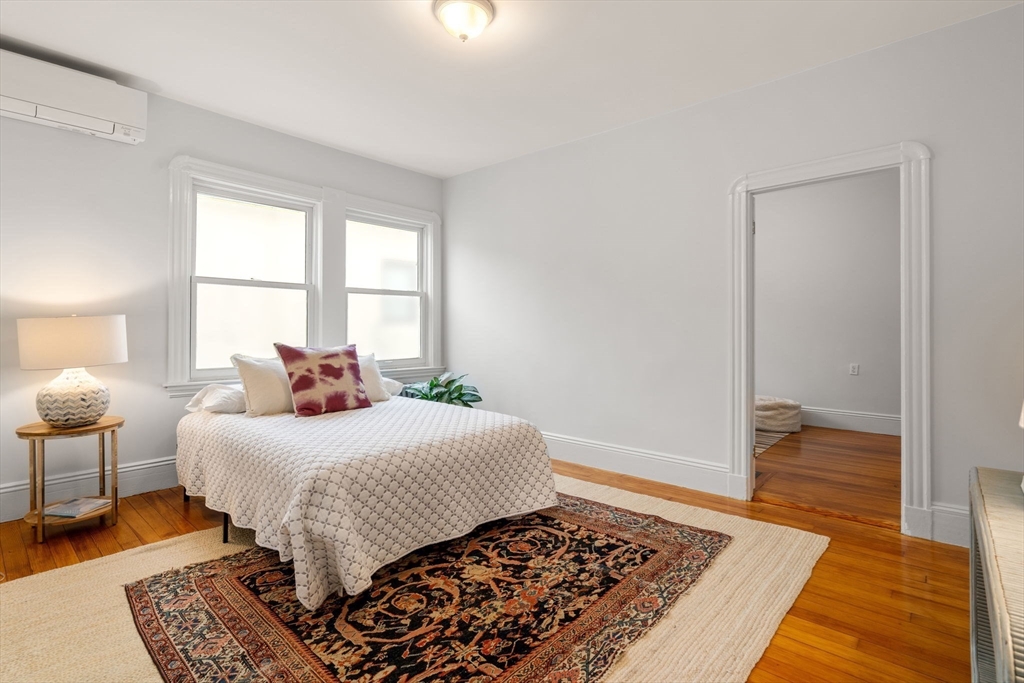 206 Pearl Street, Unit 3 Somerville, MA 02145 - Photo 13 of 18 a bedroom with a bed rug and wooden floor