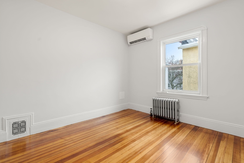 206 Pearl Street, Unit 3 Somerville, MA 02145 - Photo 15 of 18 wooden floor in an empty room with a window