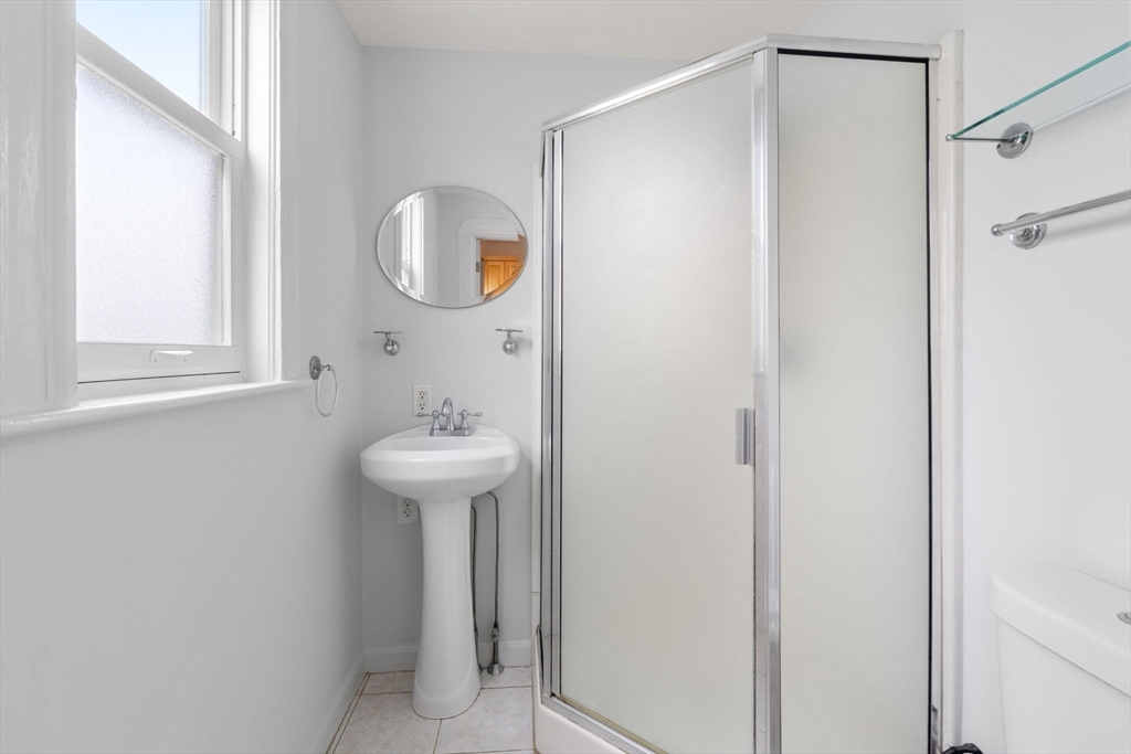 206 Pearl Street, Unit 3 Somerville, MA 02145 - Photo 17 of 18 a bathroom with a sink a mirror a window and a shower