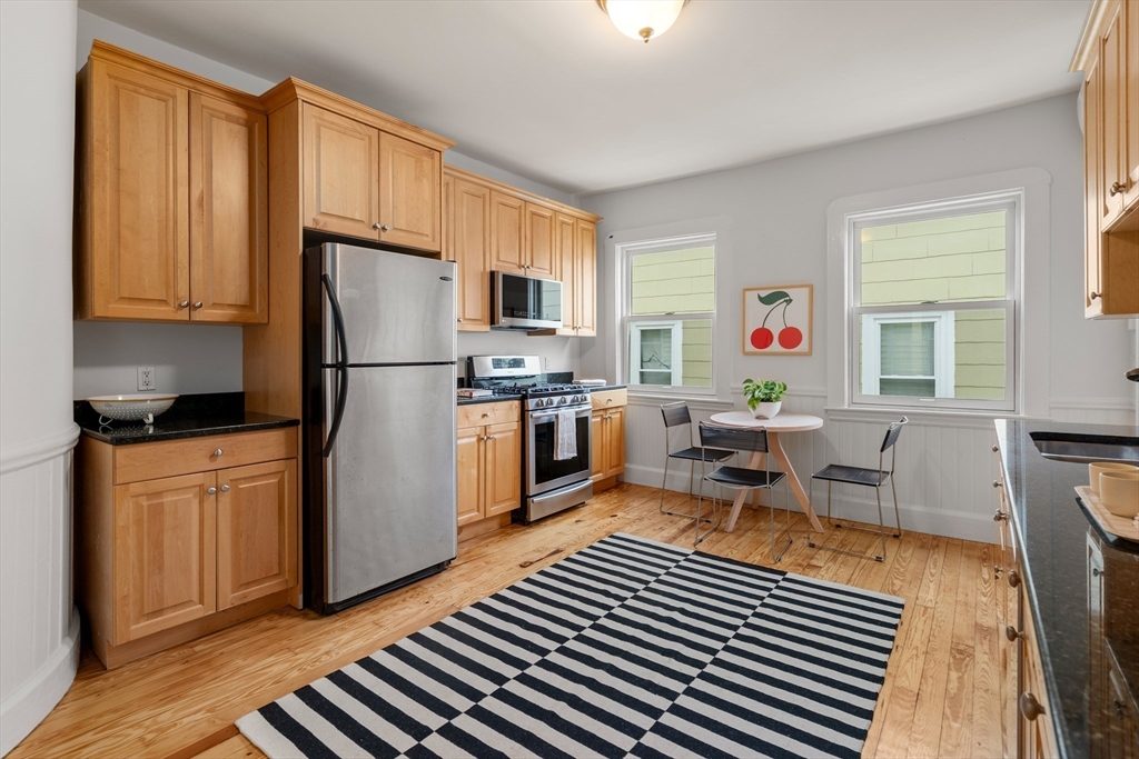 206 Pearl Street, Unit 3 Somerville, MA 02145 - Photo 10 of 18 a kitchen with stainless steel appliances a refrigerator a stove a sink cabinets and a dining table