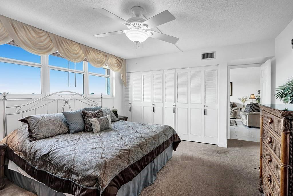 303 North Riverside Drive, Unit 503 Pompano Beach, FL 33062 - Photo 12 of 29 a bedroom with a bed and a chandelier