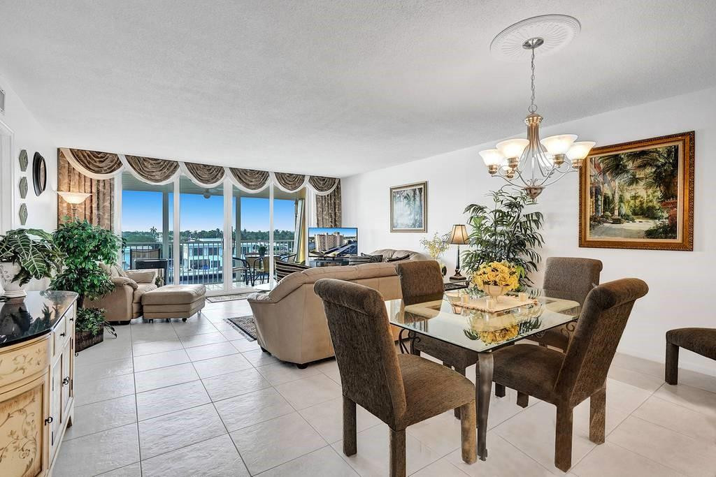 303 North Riverside Drive, Unit 503 Pompano Beach, FL 33062 - Photo 10 of 29 a dining room with furniture a chandelier and a rug