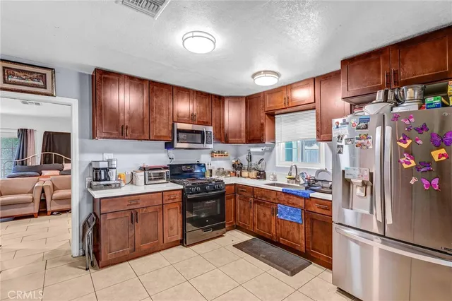 a kitchen with stainless steel appliances granite countertop a refrigerator sink and cabinets