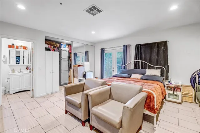 a bedroom with a bed and a refrigerator