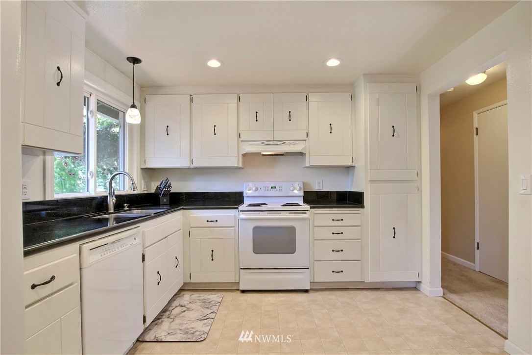 509 223rd Street Southwest Bothell, WA 98021 - Photo 11 of 39 a white kitchen with a sink dishwasher a stove and white cabinets