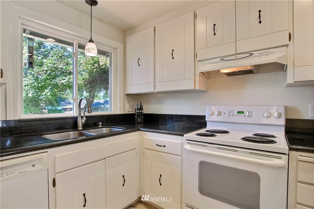 509 223rd Street Southwest Bothell, WA 98021 - Photo 12 of 39 a kitchen with granite countertop white cabinets white appliances and a sink