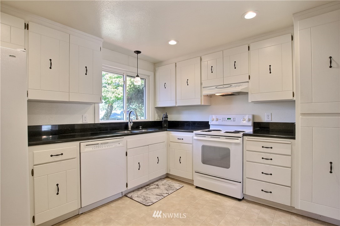 509 223rd Street Southwest Bothell, WA 98021 - Photo 9 of 39 a kitchen with granite countertop white cabinets white stainless steel appliances and sink