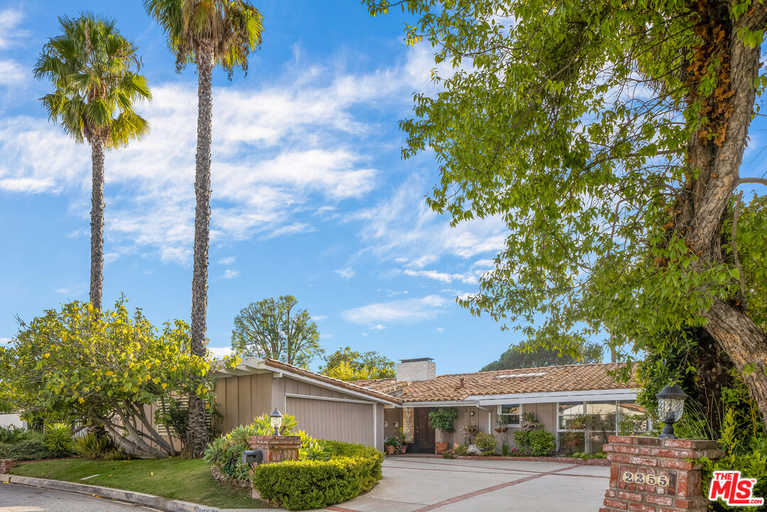 a front view of a house with a garden