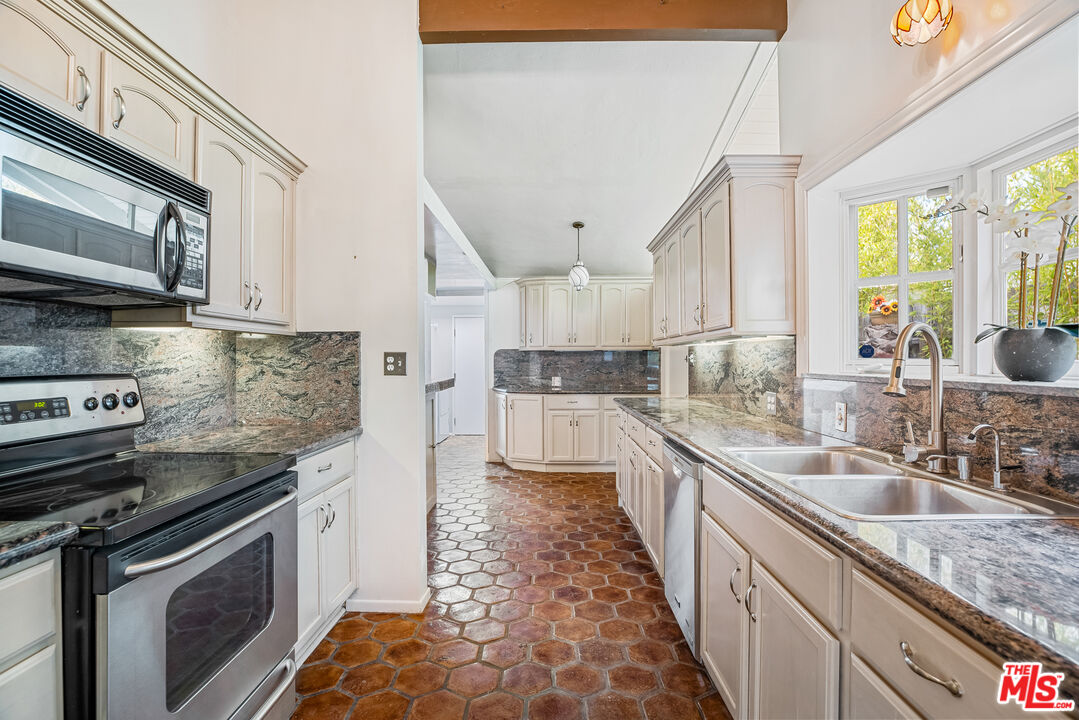 2255 Stradella Road Los Angeles, CA 90077 - Photo 11 of 33 a kitchen with stainless steel appliances granite countertop a sink stove and refrigerator