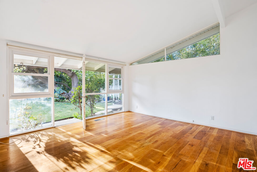 2255 Stradella Road Los Angeles, CA 90077 - Photo 19 of 33 a view of an empty room with wooden floor and a window
