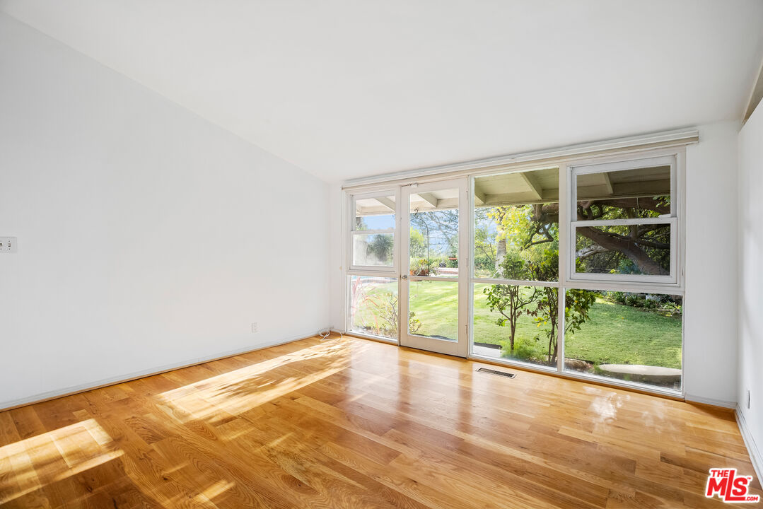 2255 Stradella Road Los Angeles, CA 90077 - Photo 20 of 33 a view of an empty room with wooden floor and a window
