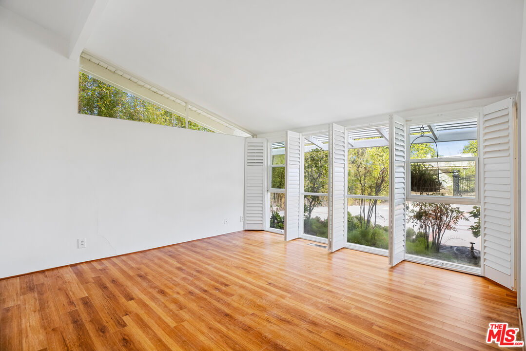 2255 Stradella Road Los Angeles, CA 90077 - Photo 22 of 33 a view of empty room with wooden floor and fan