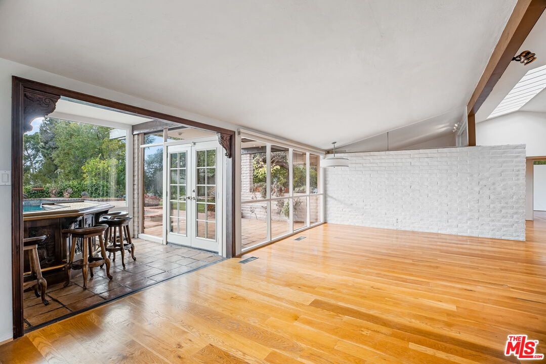 2255 Stradella Road Los Angeles, CA 90077 - Photo 8 of 33 a view of an empty room with wooden floor and a floor to ceiling window