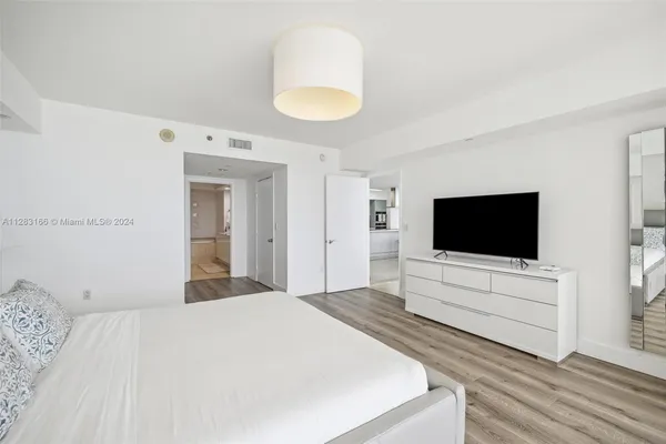 a bedroom with a bed and a flat screen tv