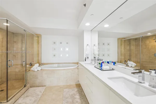 a bathroom with a tub sink mirror and shower