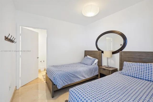 a bedroom with two beds and a potted plant