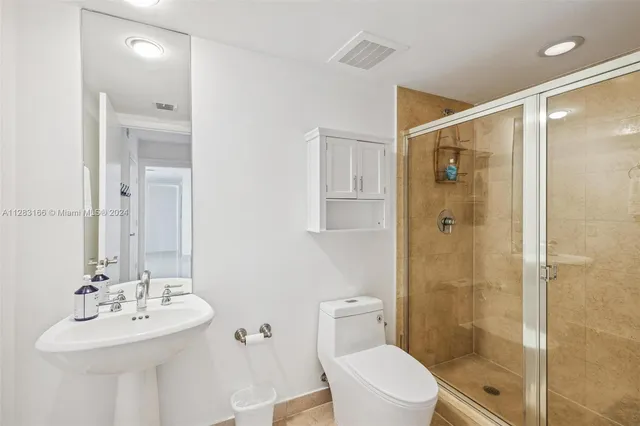 a bathroom with a sink mirror shower and toilet
