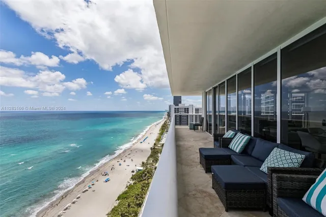 a view of swimming pool with a couches and lounge chairs