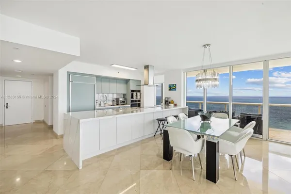 a kitchen with a dining table chairs and white appliances