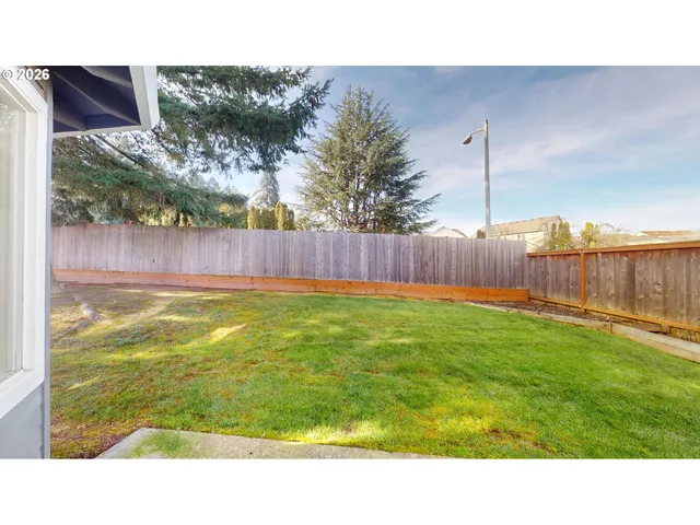 a backyard with a garden and barbeque oven