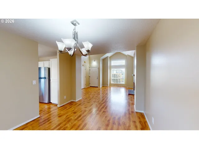 a open hall with a dining table & chairs