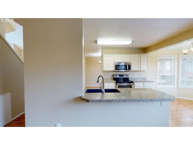 a kitchen with kitchen island stainless steel appliances a sink stove and refrigerator