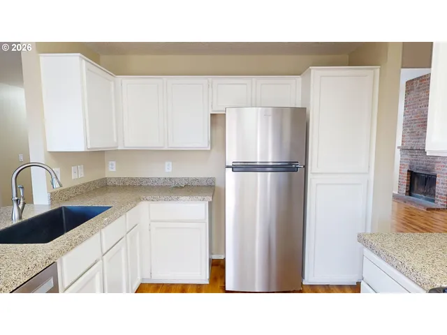 a kitchen with stainless steel appliances granite countertop a refrigerator and a sink