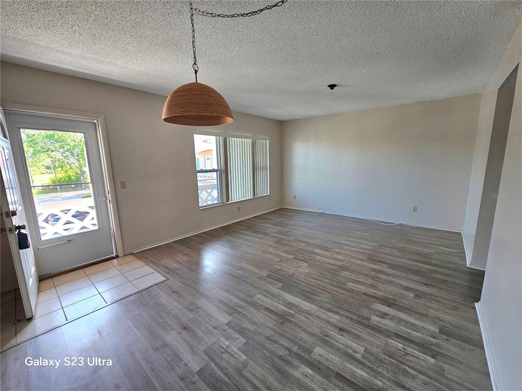 2457 Ecuadorian Way, Unit 75 Clearwater, FL 33763 - Photo 12 of 62 a view of an empty room with wooden floor and a window