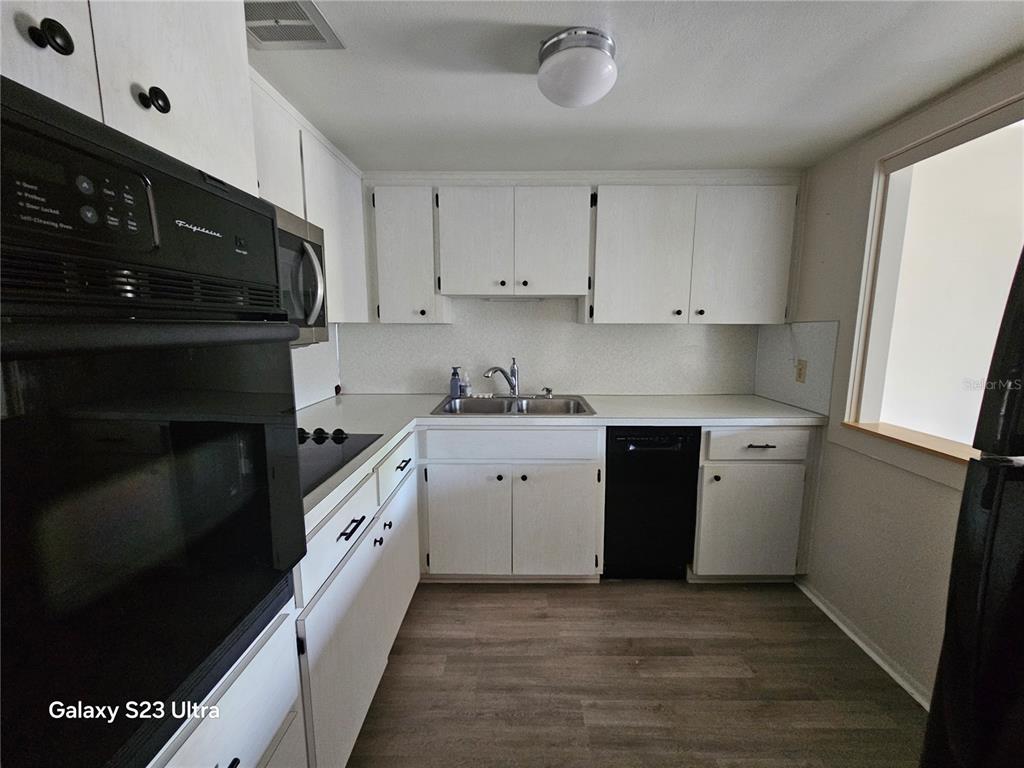 2457 Ecuadorian Way, Unit 75 Clearwater, FL 33763 - Photo 4 of 62 a kitchen with a sink stove and cabinets
