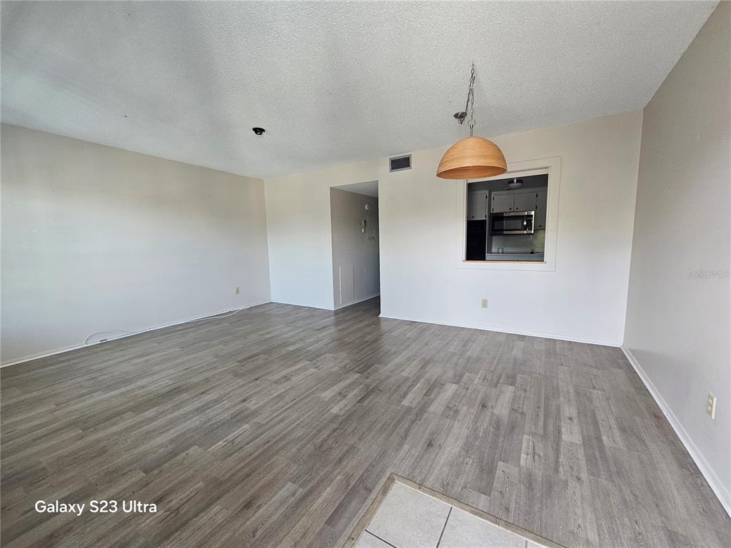 2457 Ecuadorian Way, Unit 75 Clearwater, FL 33763 - Photo 6 of 62 an empty room with wooden floor and entryway