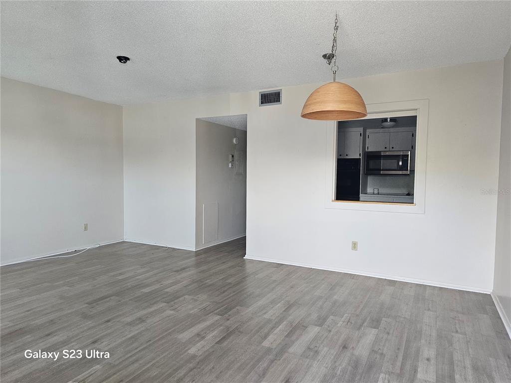2457 Ecuadorian Way, Unit 75 Clearwater, FL 33763 - Photo 7 of 62 a view of an empty room with wooden floor and a window