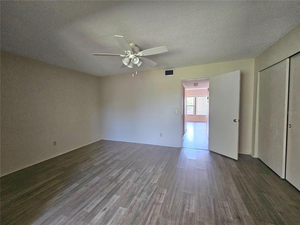2457 Ecuadorian Way, Unit 75 Clearwater, FL 33763 - Photo 8 of 62 an empty room with wooden floor and window