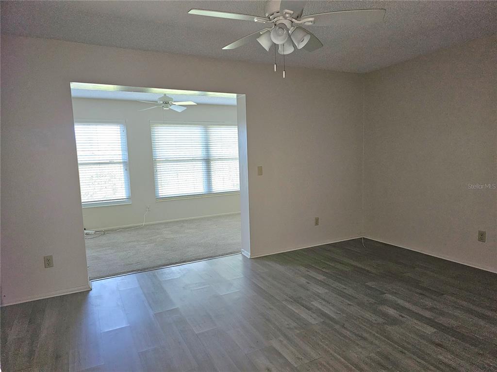 2457 Ecuadorian Way, Unit 75 Clearwater, FL 33763 - Photo 9 of 62 an empty room with wooden floor and windows